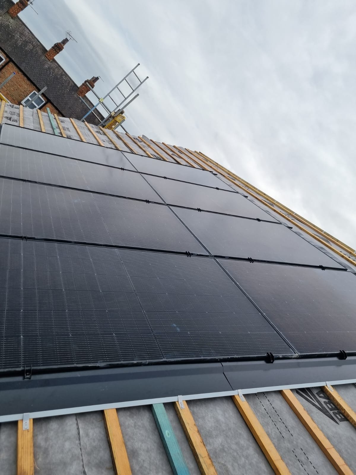 Integrated solar panels being installed safely on a UK home's roof.