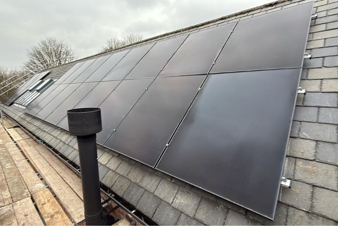 Solar panels installed across the slate roof of a UK home.